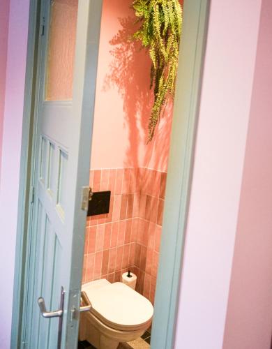 a bathroom with a toilet and a door open at Villa la Vida in Tilburg