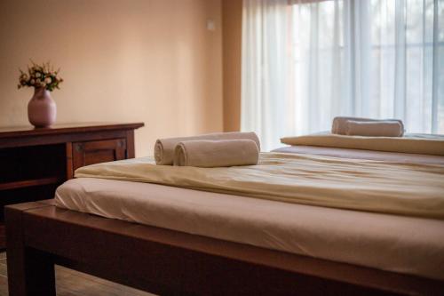 two towels on top of a bed with a window at Maya Panzio-Rezidencia in Szeged