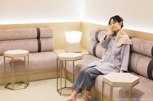 a woman sitting on a couch in a waiting room at Keio Prelia Hotel Kyoto Karasuma-Gojo in Kyoto