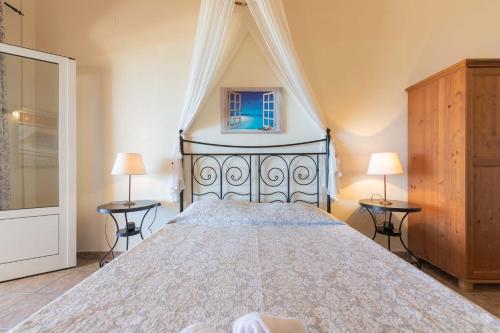 1 dormitorio con 1 cama grande y 2 lámparas en Glorious Sunset & Sea View Studio Mariastella 5 en Agios Gordios