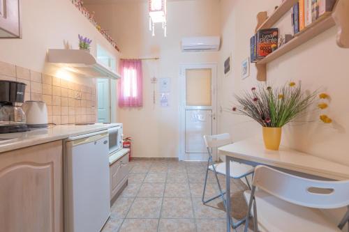 a kitchen with a counter and a table with chairs at Glorious Sunset & Sea View Studio Mariastella 5 in Agios Gordios
