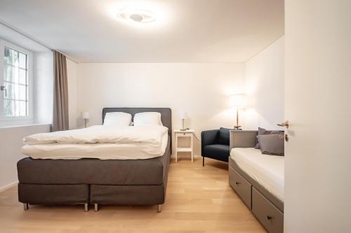una camera d'albergo con due letti e una sedia di Ferienwohnung Camping Wagenhausen a Wagenhausen