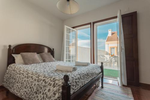 Un dormitorio con una cama y una ventana grande en Best Houses 21 - Surf House Perfect Location, en Baleal