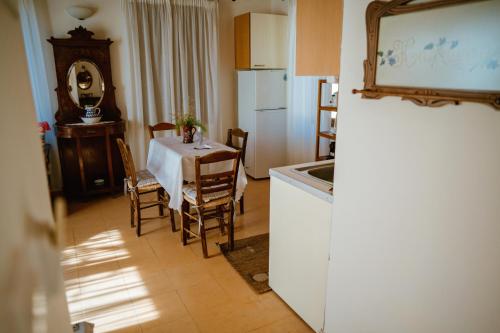 a kitchen and dining room with a table and a refrigerator at Seafront Traditional Stone House in Sunset Olive Grove - B in Alyfantá