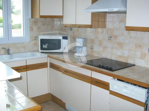 une cuisine avec des armoires blanches et un micro-ondes dans l'établissement Maison cosy proche plage avec jardin, pour 4 pers, La Tranche-sur-Mer - FR-1-357-21, à La Tranche-sur-Mer