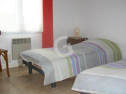 une chambre avec deux lits, une table et une fenêtre dans l'établissement Maison cosy proche plage avec jardin, pour 4 pers, La Tranche-sur-Mer - FR-1-357-21, à La Tranche-sur-Mer