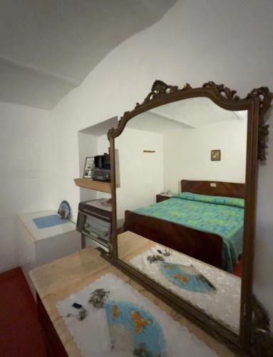 einen Spiegel in einem Schlafzimmer mit einem Bett und einem Tisch in der Unterkunft Damuz house in Calascio