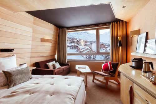 a hotel room with a bed and a window at Altapura Hôtel & Spa Val Thorens in Val Thorens
