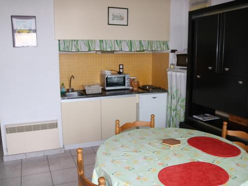 une cuisine avec une table et une cuisine avec un micro-ondes dans l'établissement Biscarrosse Plage - Duplex T2 Centre-Ville - Parking - Balcon - Proche Plage - Ménage Inclus - FR-1-319-208, à Biscarrosse-Plage