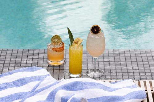 three cocktails on a table next to a swimming pool at Meliá Orlando Celebration in Orlando