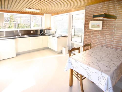 a kitchen with a table and a brick wall at Elli in Cadzand-Bad