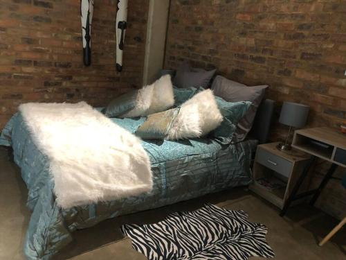 Una cama con almohadas en una habitación. en 317 Maboneng On Craft, en Johannesburgo