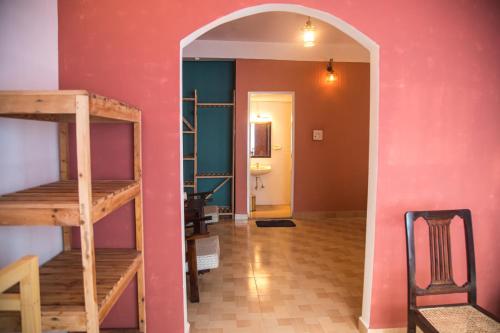 um arco que conduz a uma sala com uma parede cor-de-rosa em Coco Moon em Morjim