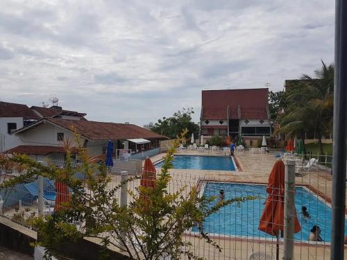 a view of a swimming pool with umbrellas at Estada inesquecível 01 Guarapari in Guarapari