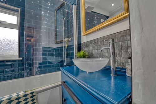 a bathroom with a bowl sink on a blue counter at Guest Homes - Loughborough Road House in Leicester