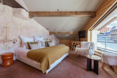 a bedroom with a large bed and a window at Altapura Hôtel & Spa Val Thorens in Val Thorens