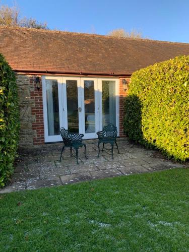 two benches sitting in front of a house at Holbrook Manor & Spa in Wincanton