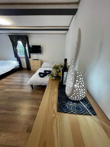 a room with a table with a bottle of wine and flowers at Agroturystyka Ranczo Gościszów in Nowogrodziec