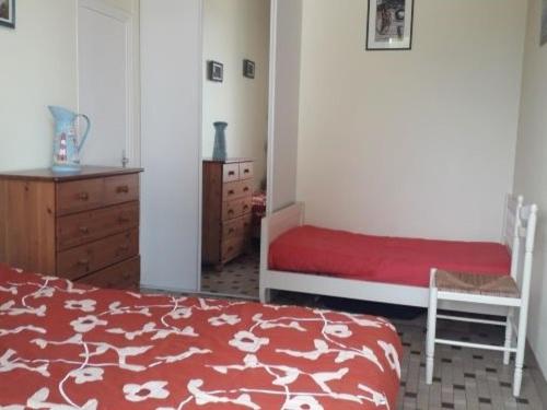 1 dormitorio con cama, silla y vestidor en Maison La Faute-sur-Mer, 2 pièces, 3 personnes - FR-1-476-144, en La Faute-sur-Mer