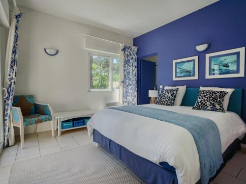 une chambre avec un grand lit aux murs bleus dans l'établissement Villa à Biscarrosse avec piscine chauffée et jardin pour 6 personnes - FR-1-521-93, à Biscarrosse