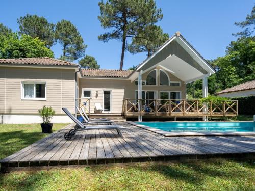 une maison avec une terrasse et une piscine dans l'établissement Villa à Biscarrosse avec piscine chauffée et jardin pour 6 personnes - FR-1-521-93, à Biscarrosse