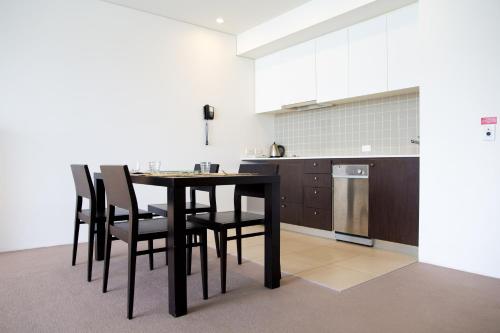 a kitchen with a table and chairs in a room at Cairns Private Apartments in Cairns