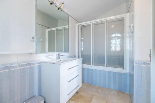 een badkamer met een wastafel, een spiegel en een raam bij Las Ramblas in Orihuela