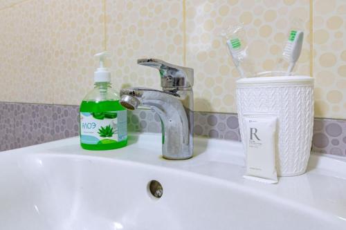 um lavatório de casa de banho com um suporte de escova de dentes e uma torneira em ЖК 7Я em Astana