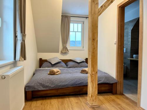 a bedroom with a bed with two wooden posts at Chata Hubertka Krkonoše in Vítkovice