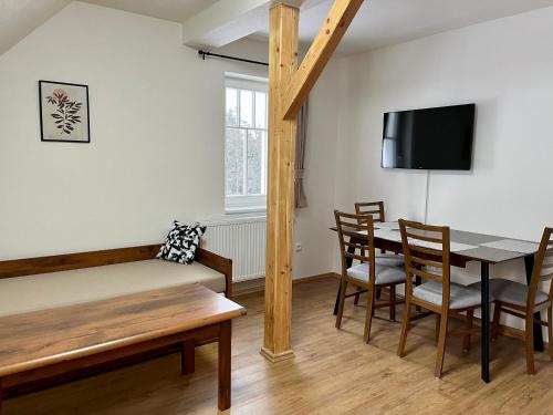 a room with a bed and a table and chairs at Chata Hubertka Krkonoše in Vítkovice