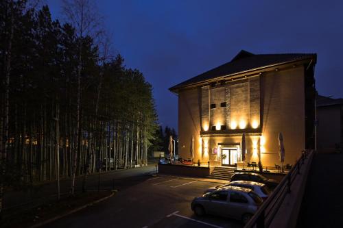 a building with cars parked in a parking lot at night at Apartment White Bear in Zlatibor