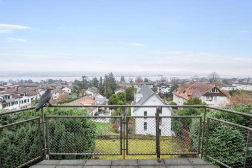 a bird perched on a fence overlooking a city at Villa Bellevue Rüschlikon in Rüschlikon