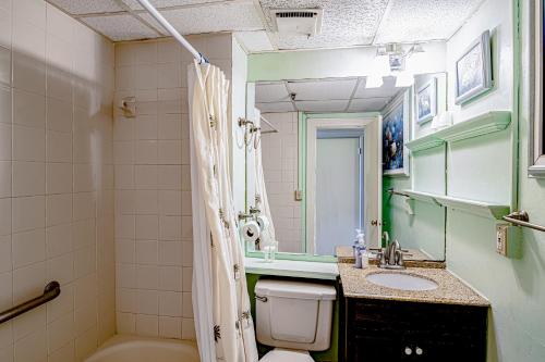 a bathroom with a toilet and a sink and a mirror at Historic Palm Beach Hotel #1106 in Palm Beach