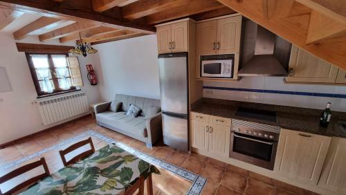 a kitchen with wooden cabinets and a couch in a room at Apartamento Casa Male in Pimiango