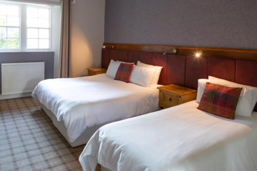 a hotel room with two beds and a window at The Glen Guesthouse in Selkirk