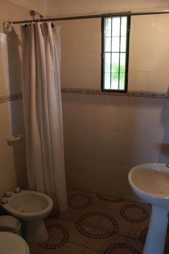 a bathroom with a white shower curtain and a sink at Vista del sol in Villa Ciudad Parque