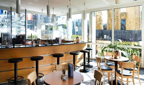 a restaurant with tables and chairs and a bar at Familienhotel Citylight in Berlin