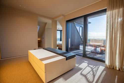 ein Schlafzimmer mit einem Bett und einem großen Fenster in der Unterkunft The Penthouse Nami, Branding, Ultra Luxurious Japanese Design Sea View in Cadzand