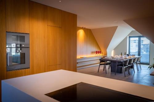 eine Küche und ein Esszimmer mit einem Tisch und Stühlen in der Unterkunft The Penthouse Nami, Branding, Ultra Luxurious Japanese Design Sea View in Cadzand