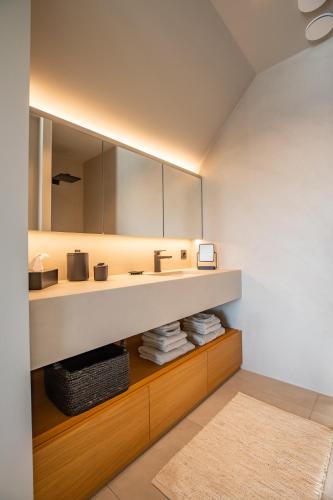 a bathroom with a sink and a mirror at The Penthouse Nami, Branding, Ultra Luxurious Japanese Design Sea View in Cadzand