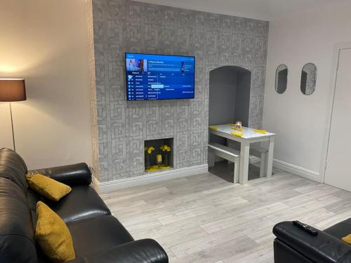a living room with a couch and a tv on a wall at Coastal Retreat-NEW DAY PROPERTIES-next to beach in South Shields