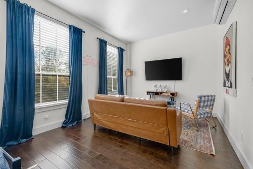 a living room with a couch and a tv at The Murray in Bentonville