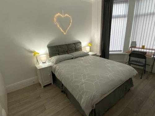 a bedroom with a bed with a heart on the wall at Coastal Retreat-NEW DAY PROPERTIES-next to beach in South Shields