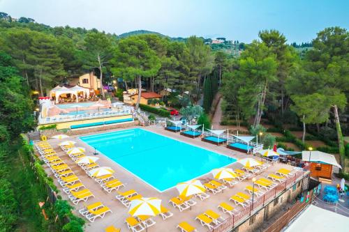 an overhead view of a pool with chairs and umbrellas at Le Pianacce Camping Village in Castagneto Carducci
