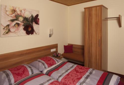 ein Schlafzimmer mit einem Bett und einem Wandgemälde in der Unterkunft Hotel Restaurant zum Schwanen in Bruchköbel