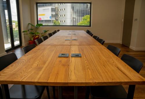 a large wooden conference table in a room with chairs at BlackBrick Sandton Two in Johannesburg