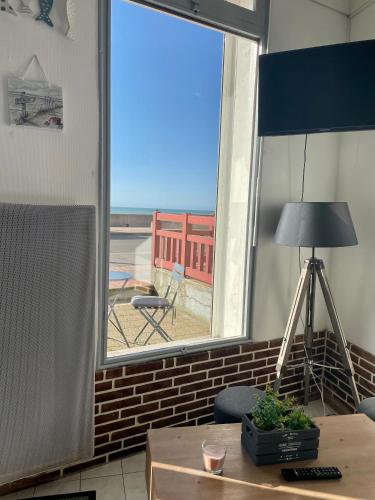 Cette chambre dispose d'une fenêtre offrant une vue sur l'océan. dans l'établissement Le Front de mer - studio lumineux esplanade Mers, à Mers-les-Bains