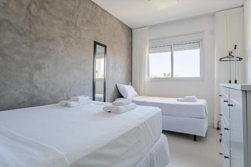 Habitación blanca con 2 camas y espejo. en WI-FI 300MB | 500m do mar | Churrasqueira #IA21, en Florianópolis