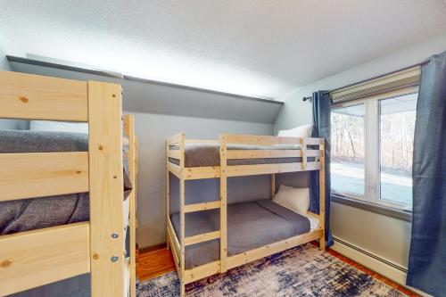 two bunk beds in a room with a window at Riverbend Retreat in Jay