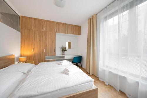 a bedroom with a white bed and a large window at Apart Hotel VIRGO in Bratislava